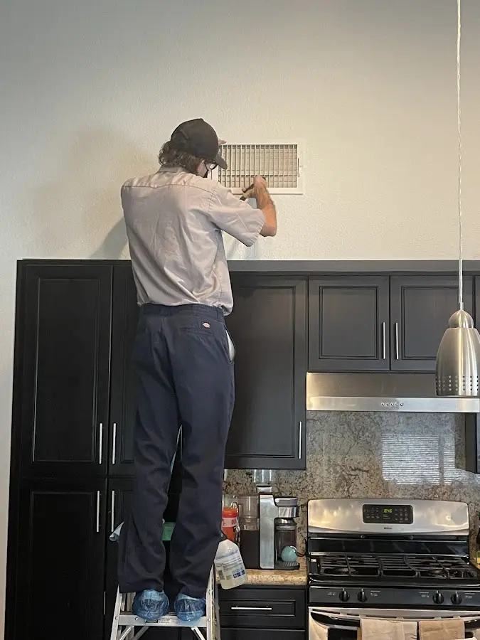 Technician inspecting an air vent during HVAC service in Cortland